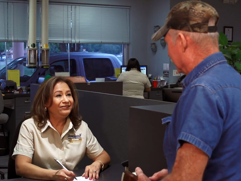 A Sharyland employee helping a customer pay his bill in the office.